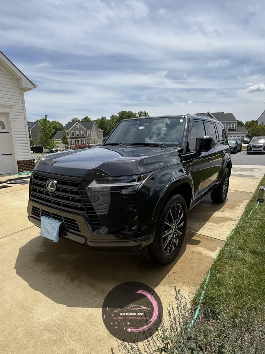 Black Lexus SUV on a wet driveway after a wash