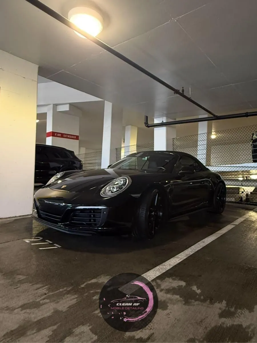 Black Porsche 911 detailed in a parking garage