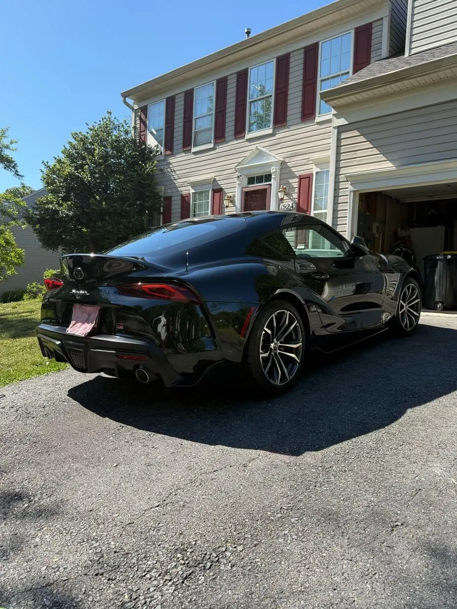 Rear three quarter view of a black Toyota Supra outside a house